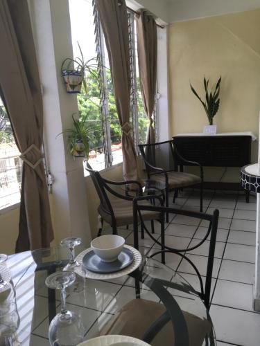 a dining room with a glass table and chairs at Posada Colonial Beach Villas in San Juan