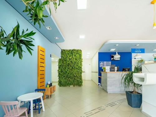 皮拉西卡巴ibis budget Piracicaba的一个带绿色墙壁和桌椅的办公室