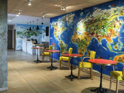 a large mural of the world on a wall in a restaurant at ibis budget Aéroport Lyon Saint Exupéry in Saint-Exupéry