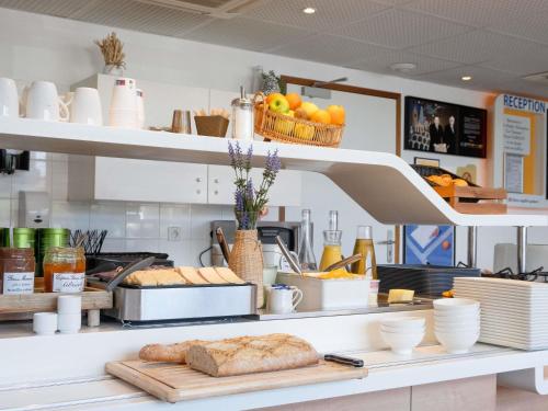 a kitchen with bread and other items on a shelf at ibis budget Montauban Les Chaumes in Montauban
