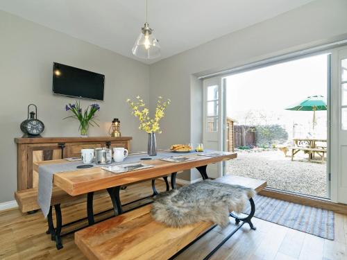a dining room with a table and a large window at Pinfold Cottage in Richmond