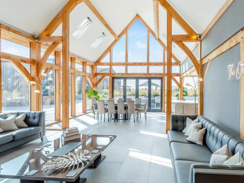 een woonkamer met houten plafonds en een eetkamer bij Oakwood Barn in Cawood