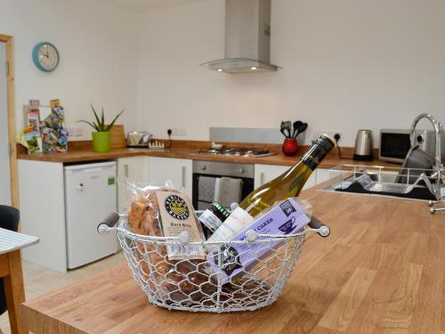 a basket with a bottle of wine on a kitchen counter at Y Gweithdy in Barmouth
