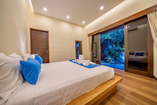 a bedroom with a large bed and a large window at Seminyak Happy Villa in Legian