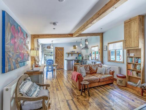 a living room with a couch and a kitchen at The Nutshell in Pluckley