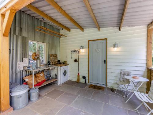 a patio with a stove and a table and a door at The Nutshell in Pluckley