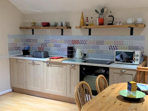 a kitchen with a table and a counter top at Sandpipers in Pyworthy