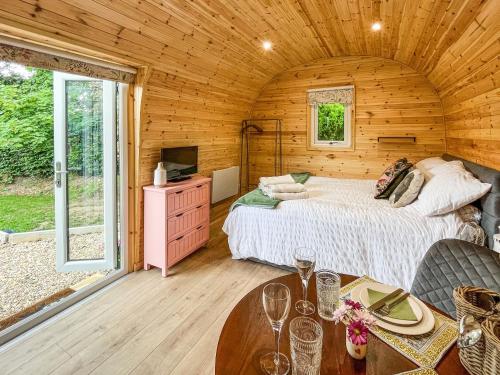a bedroom with a bed in a wooden cabin at Thula Lodge in Chichester