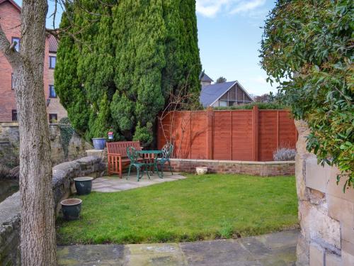 a garden with a table and a bench and a fence at Beckbridge House in Pickering