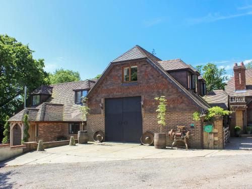 a brick house with a garage in front of it at Coombe Wood Coach House in Hawkinge