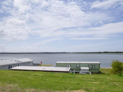 a house on the shore of a body of water at Coastal Comfort in Tosside