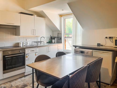 a kitchen with a wooden table and chairs in it at Sherwood House Apartment 3 in Bakewell