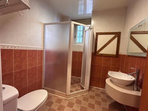 a bathroom with a shower and a toilet and a sink at Euro Country Villa in Renai