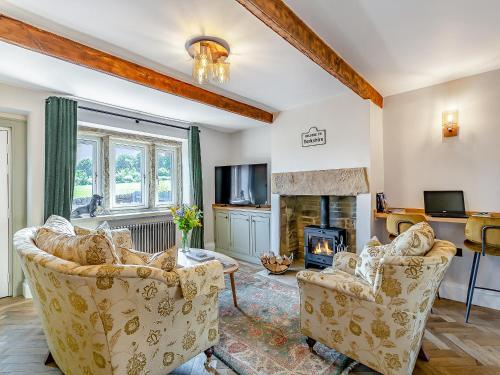 a living room with two chairs and a fireplace at May Cottage in Luddenden Foot