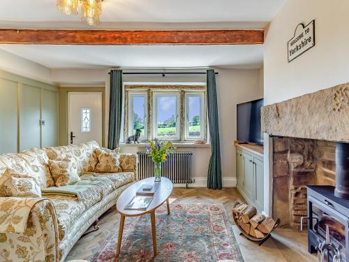 a living room with a couch and a fireplace at May Cottage in Luddenden Foot