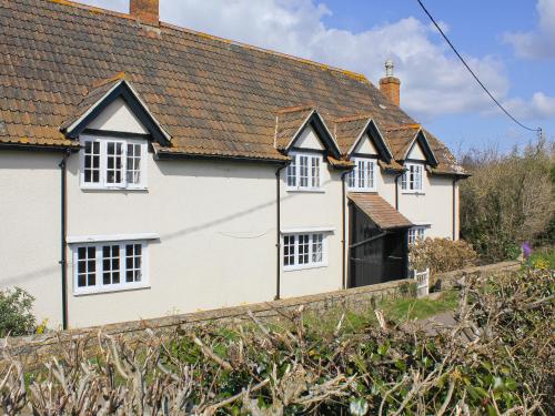 a row of white houses with black roofs at Dairy House Farm in Hatch Beauchamp