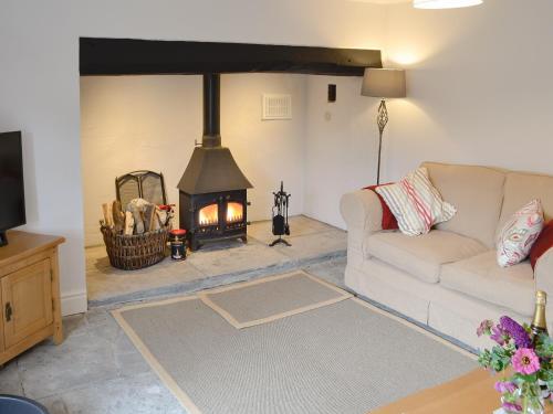 a living room with a couch and a fireplace at Dairy House Farm in Hatch Beauchamp