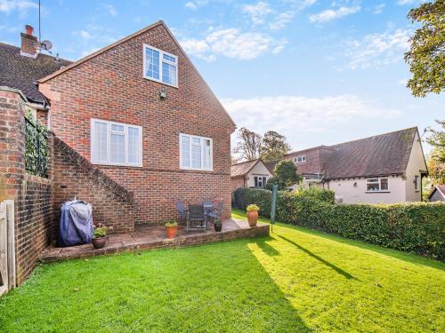 a brick house with a lawn in the yard at Little Longmead in Findon