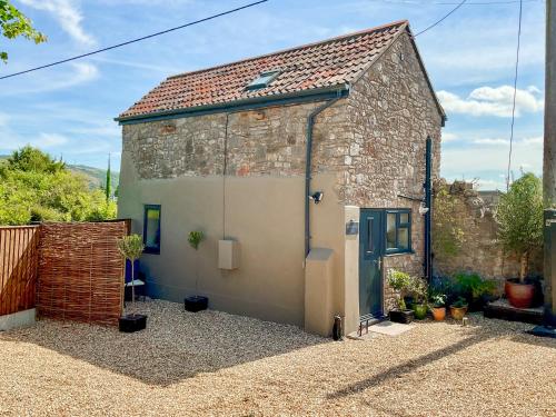 a small stone building with a blue door at The Old Posthouse Barn - Uk50191 in Badgworth
