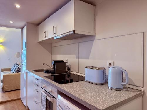 a kitchen with white cabinets and a counter top at Lovely Estoril Apartment in Estoril