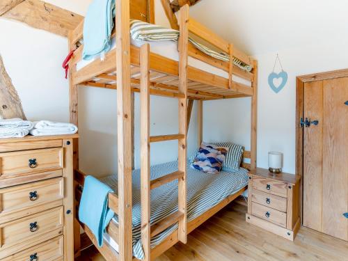 a bedroom with a bunk bed with a wooden bunk bed frame at Wern Farm Barn in Cwmdu