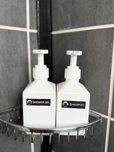two bottles of soap on a shelf in a bathroom at Blu Monkey Hub & Hotel Surat Thani in Surat Thani