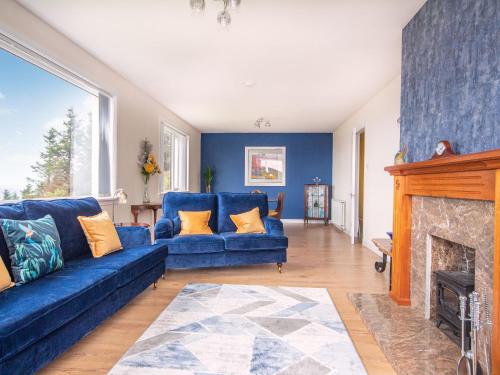 a living room with a blue couch and a fireplace at Sunny Hill - Ukc6884 in Aultgrishin