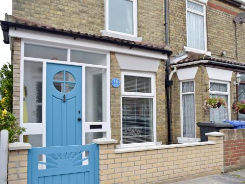 a house with a blue door and a blue chair at Albion Cottage in Pakefield