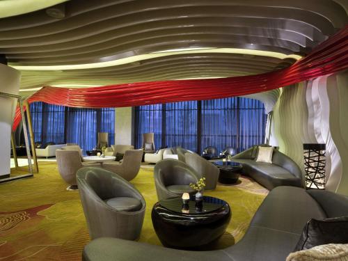 a large room with couches and tables andwindows at Sofitel Kunming in Kunming