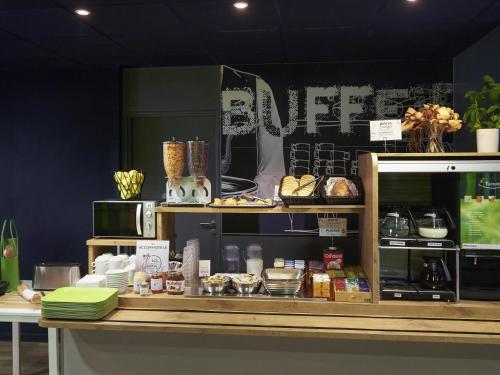 a bakery with a counter with food on it at ibis budget Cholet Centre in Cholet