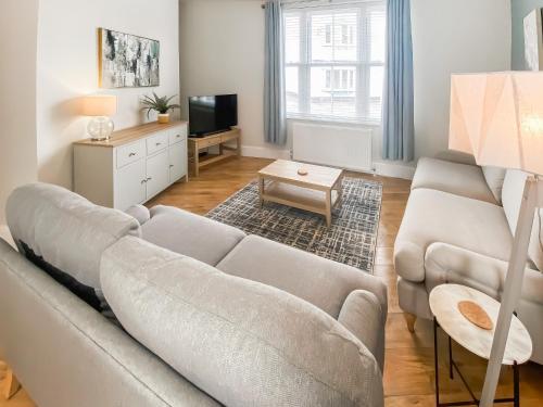 a living room with a couch and a tv at Low Tide - Uk50362 in Filey