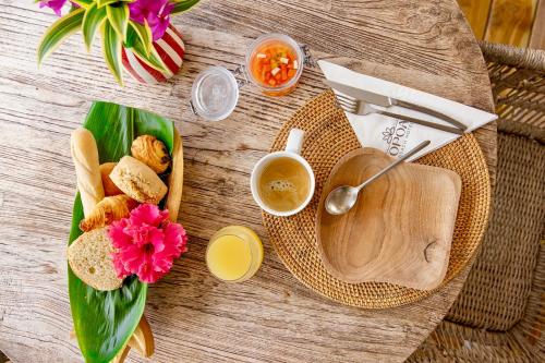 a table with a plate of bread and a bowl of soup at Opoa Beach Hotel in Opoa
