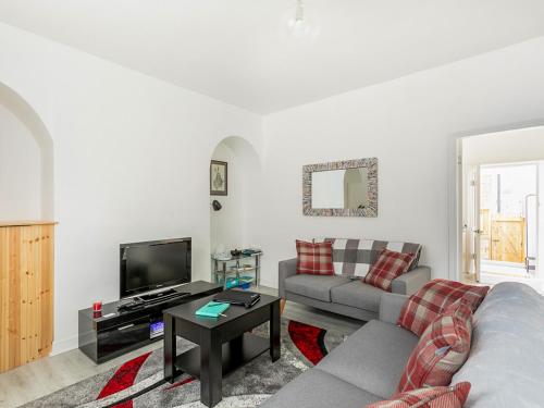 a living room with a couch and a tv at Castle Retreat in Skipton