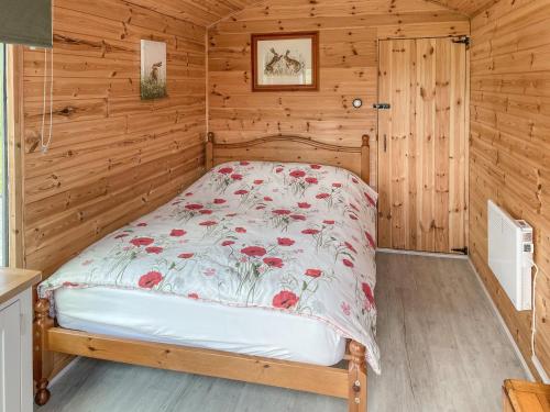 a bedroom with a bed in a log cabin at Hare's Rest in Ellesmere