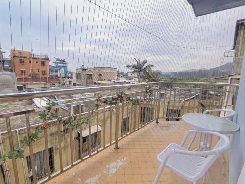 a balcony with a chair and a view of a city at 厦门哈哈虎客栈 in Xiamen