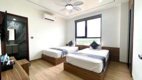a bedroom with two beds and a ceiling fan at Hoa Lư City Hotel in Ninh Binh