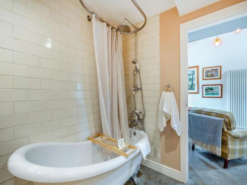 a bathroom with a white tub and a shower at The Coop in West Bradford