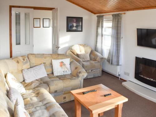 a living room with two couches and a tv at Tranquillity in Millom