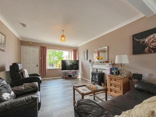 a living room with a couch and a tv at Little Orme Cottage in Penrhyn Bay