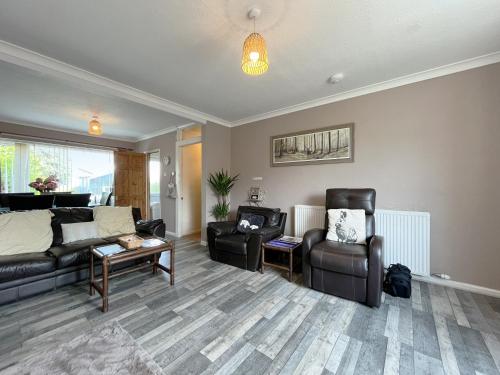 a living room with a couch and chairs at Little Orme Cottage in Penrhyn Bay