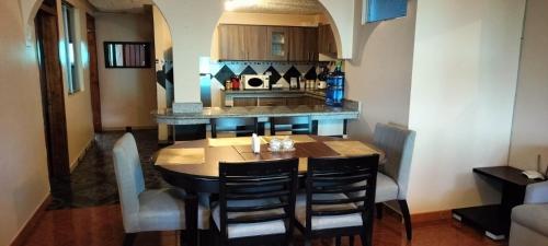 a kitchen with a table with chairs and a counter at Full apartment, with cinema in Riobamba