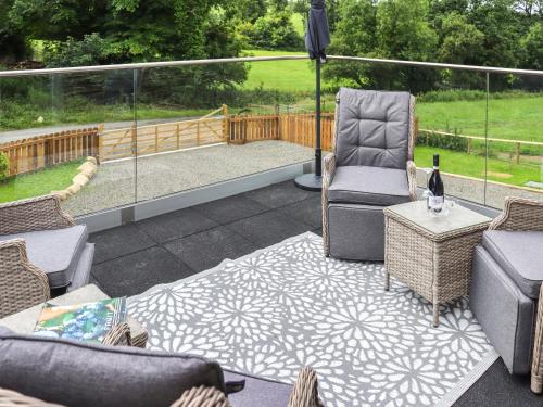 a patio with two chairs and a table and an umbrella at Y Felin in Llandissilio