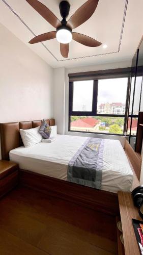 a bedroom with a large bed with a ceiling fan at Hoa Lư City Hotel in Ninh Binh