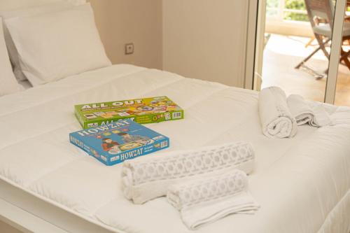 Una cama con dos libros y toallas. en Welcome to Tamaris Escape 2BR Sea & Vue Piscine, en Dar Mohammed Ould Haj Jilali