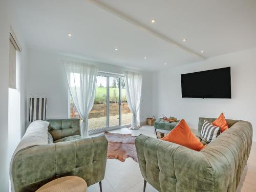 a living room with two couches and a flat screen tv at Hillside House in Berwick-Upon-Tweed
