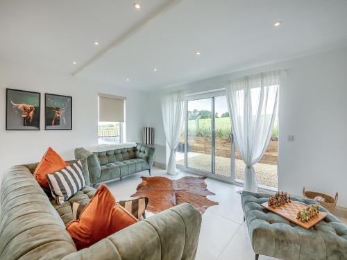 a living room with two couches and a large window at Hillside House in Berwick-Upon-Tweed
