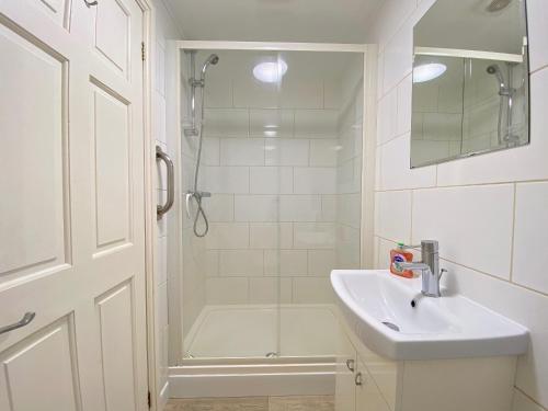 a white bathroom with a shower and a sink at Brown Snout in Ledbury