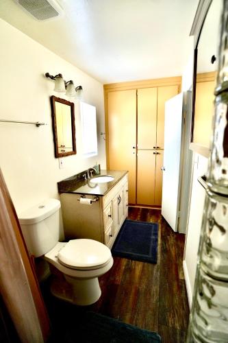 a bathroom with a white toilet and a sink at La Casita Poolside Retreat in Lake Elsinore