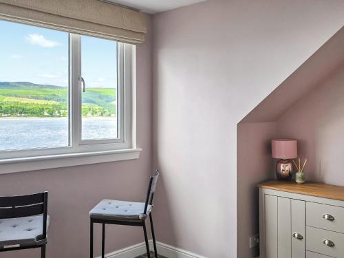 a room with a window with a chair and a table at Holy Loch View in Strone