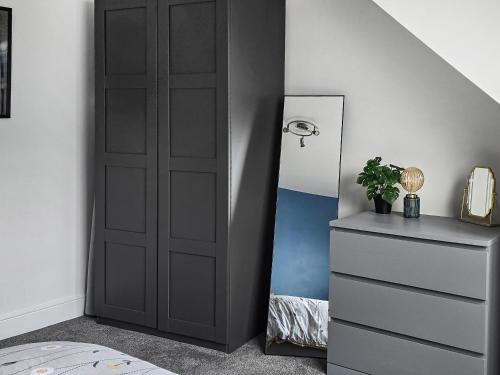 a bedroom with a black door next to a dresser at Holy Loch View in Strone